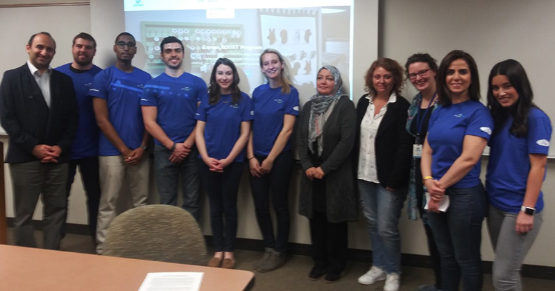 Associate Professor of Business Administration Omid Sabbaghi, left, students and representatives of Zaman International.