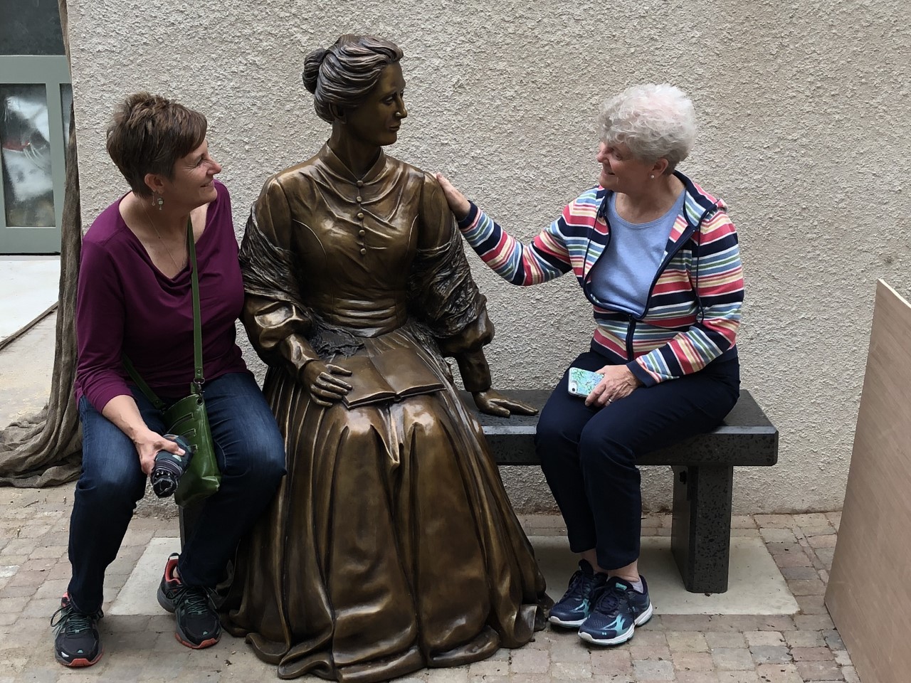 Mary Serowoky, left, and Judy Mouch, RSM, sit with a statue of Catherine McAuley.
