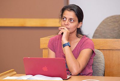 A woman uses her computer during an MBA class.