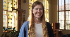 MacKenzie Patterson smiles and stands inside St. Ignatius Chapel.