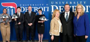 Seven people pose for a photos, three holding lamps, in front of a blue University of Detroit Mercy backdrop, inside of the Student Union.