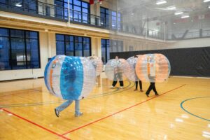 An image of students encased in Bubbleballs playing a game.