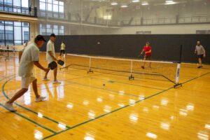 Four pickleball players compete in a match on the Student Fitness Center courts.