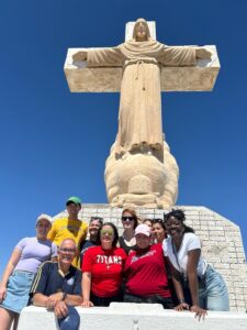 An image of several adults standing before a Cross