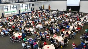 An overhead of dozens of people sitting at tables inside of the Student Fitness Center during 2024 President's Convocation.