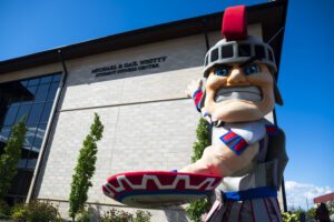 Tommy Titan helps unveil the new Michael and Gail Whitty Student Fitness Center outdoors during a ceremony.