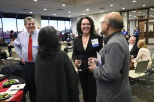 Faculty members stand and chat with one another during a faculty recognition event in 2024.