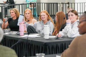 Five students sit at a table during the Ethics Bowl, held inside of the Student Union.
