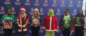 An image of 6 individuals wearing Christmas sweaters.