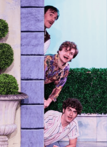 An image of three men looking out from behind a wall.