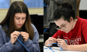Cybersecurity students work with wires.