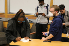 Nandi Comer autographs a book for a student.