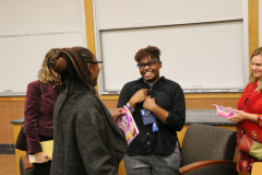 Nandi Comer signs a book for a student.