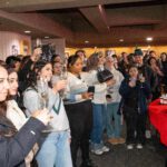 Dozens of the students toast inside of the Titan Club.
